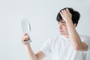 髪を気にする男性の写真画像