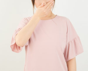 臭いに鼻をおさえる女性の写真画像